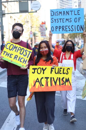 Three students holding signs at a climate protest