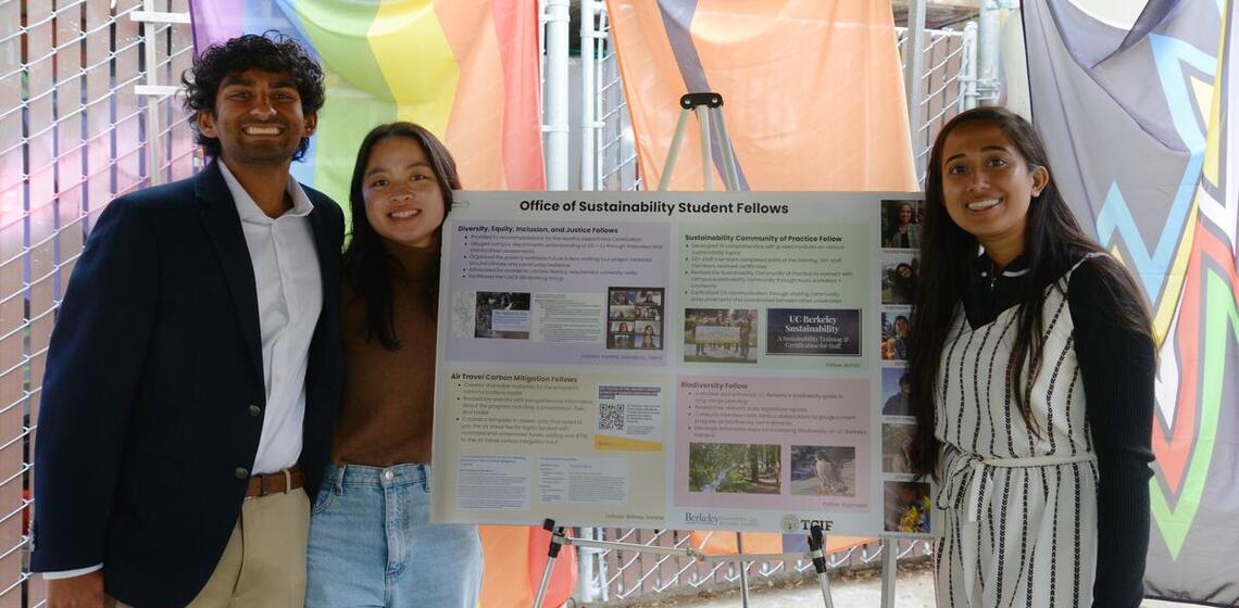 3 students next to a poster board