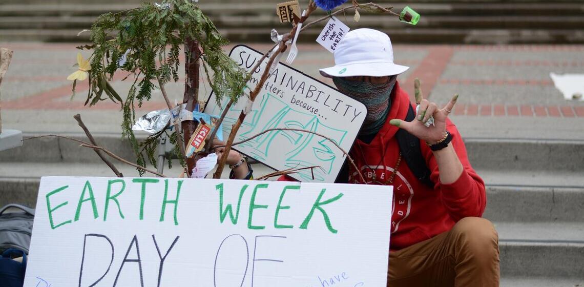 Earth Week Protestor with a sign on Sproul Plaza