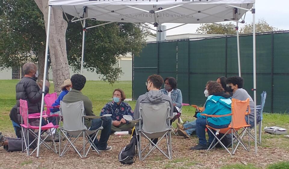 People sit in chairs in a circle