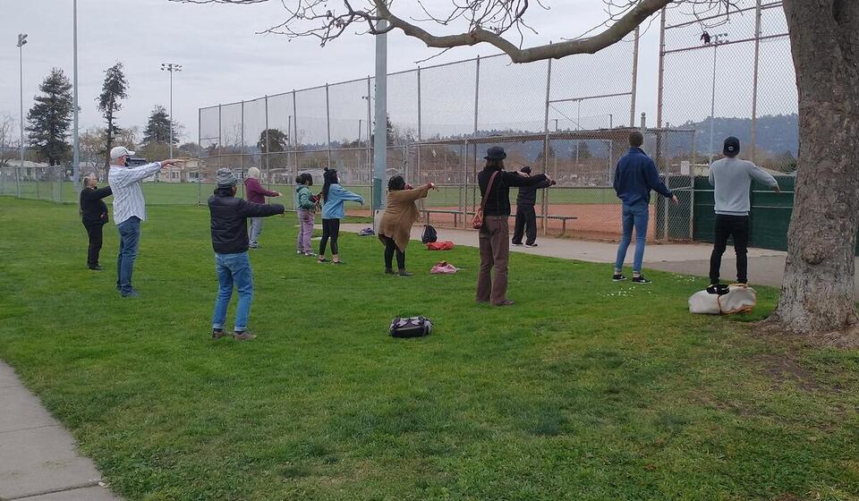People stand in a circle on grass